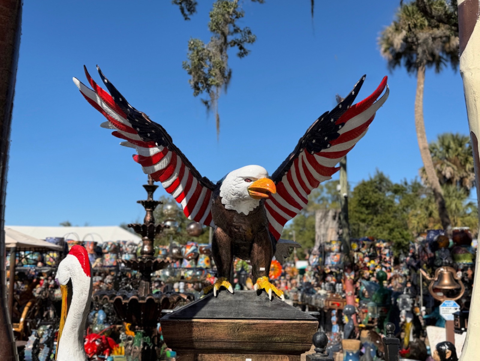 Outdoor Barberville Yard Art Emporium display with a giant eagle sculpture and acres of colorful yard art behind it