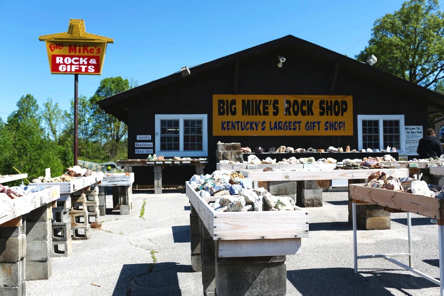 Big Mike's Rock & Gift Shop exterior with outdoor rock tables and its roadside sign