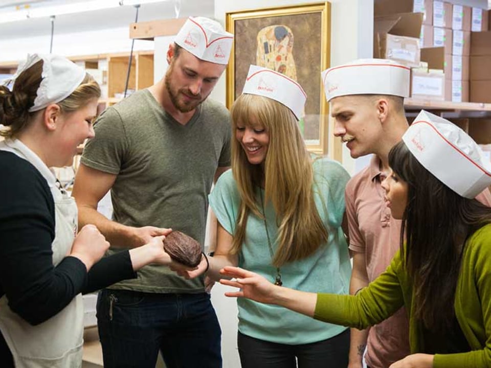 Boehm's Candies guide showing chocolate to visitors inside the Issaquah factory