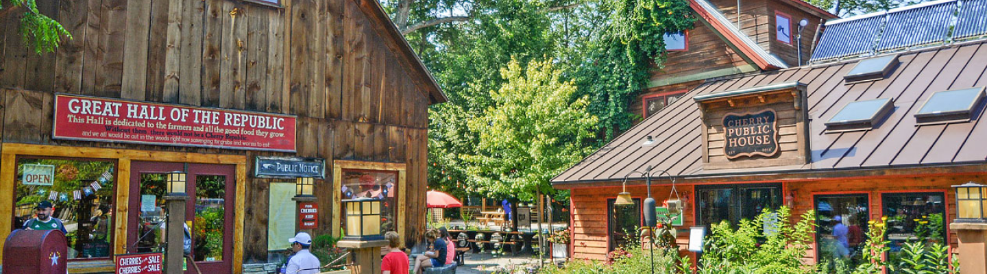 Wide view of Cherry Republic's Glen Arbor campus showing the Great Hall and Cherry Public House buildings with red signage