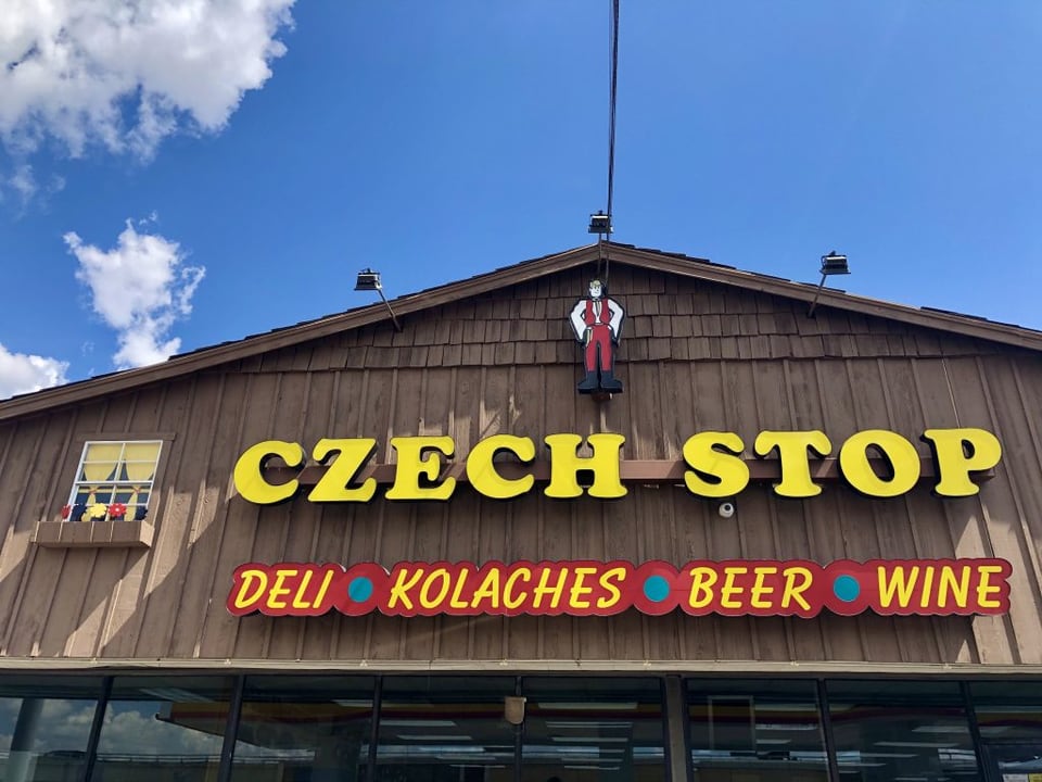 Wooden Czech Stop storefront in West with yellow sign and deli, kolaches, beer and wine lettering