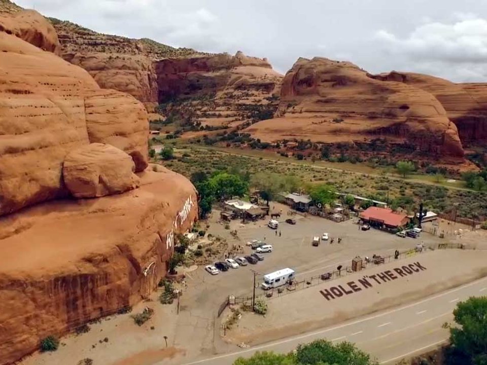 Aerial view of the Hole N” the Rock roadside property carved into red sandstone south of Moab