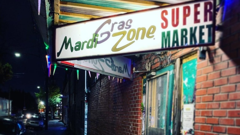 Illuminated Mardi Gras Zone Supermarket sign above the Royal Street entrance at night
