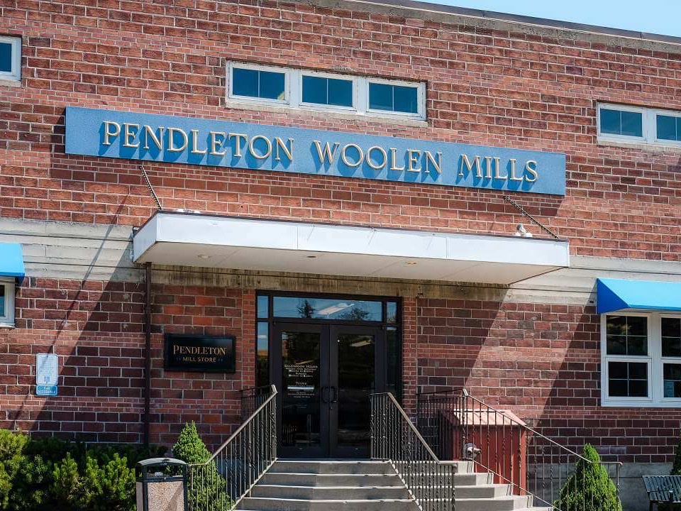 Brick Pendleton Woolen Mills entrance with the Pendleton Mill Store sign beside the doors