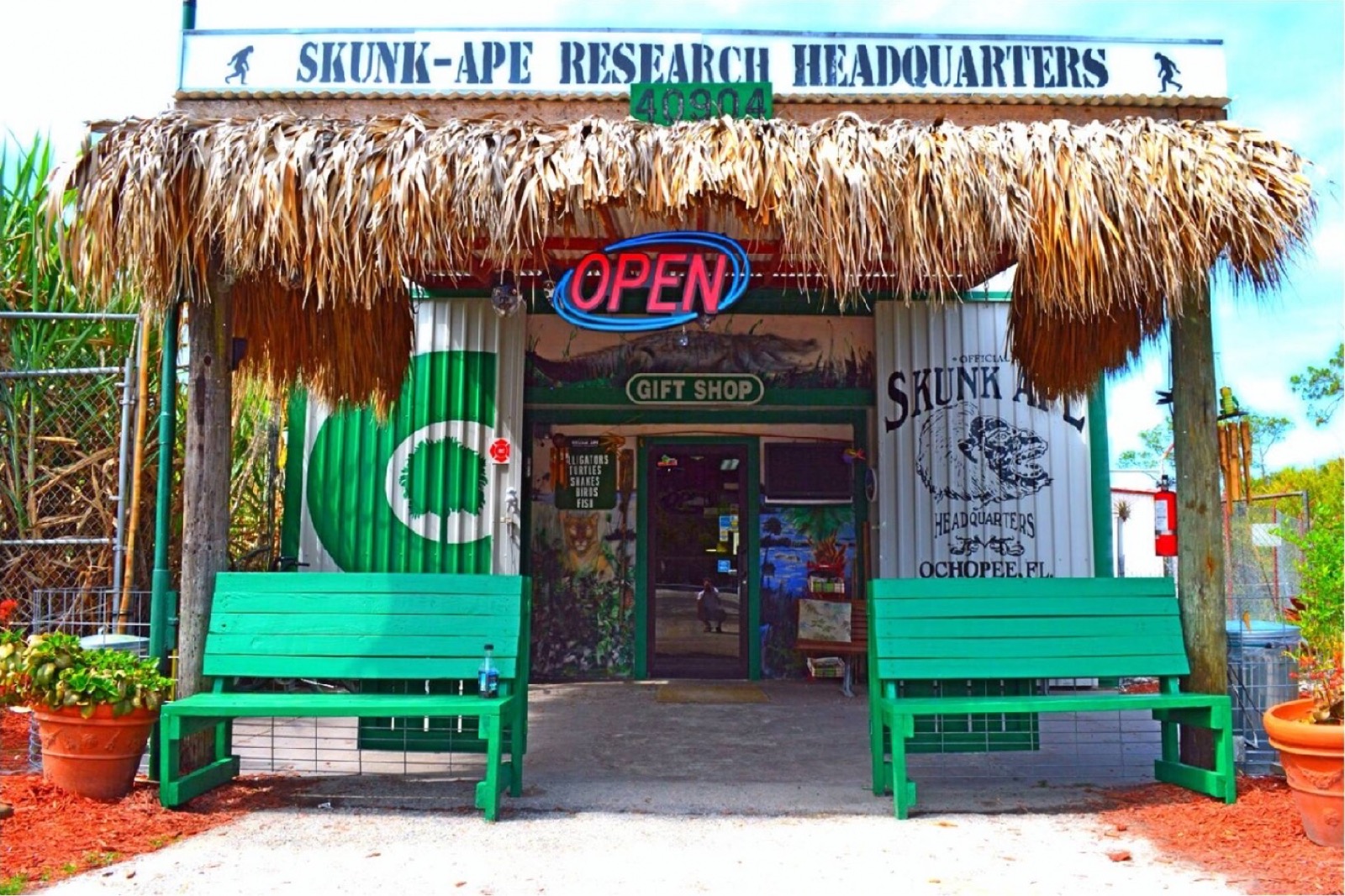 Thatched entrance to the Skunk Ape Research Headquarters gift shop in Ochopee with its large roadside sign