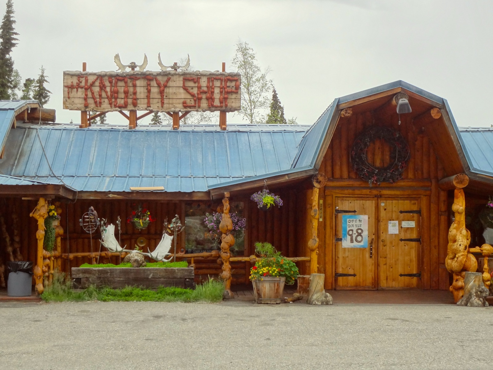 Rustic exterior of The Knotty Shop in Salcha with its large burl-wood sign