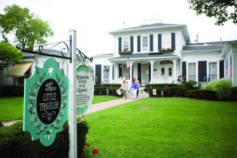The Little Traveler's historic mansion storefront in Geneva with the business sign beside the entrance