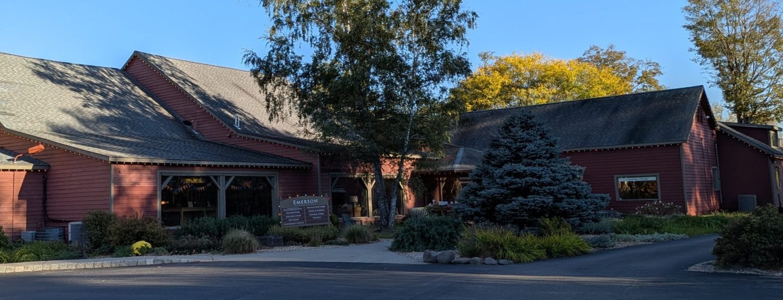 Red barn-like Shops at Emerson buildings with the Emerson retail directory sign beside the entrance