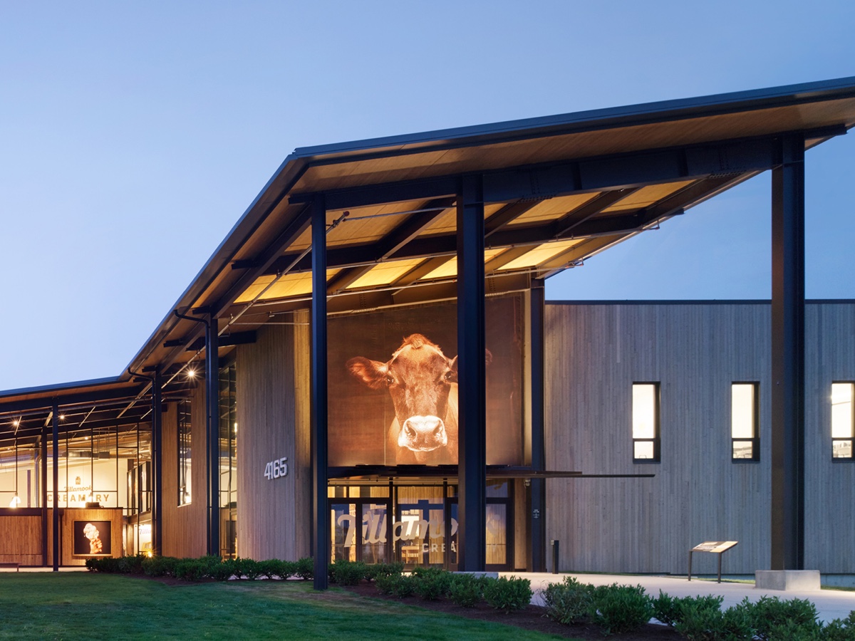 Modern Tillamook Creamery entrance at 4165 with its illuminated cow portrait and glass visitor doors