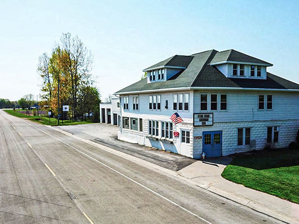 The white Union Star Cheese Factory building beside County Road II near Fremont